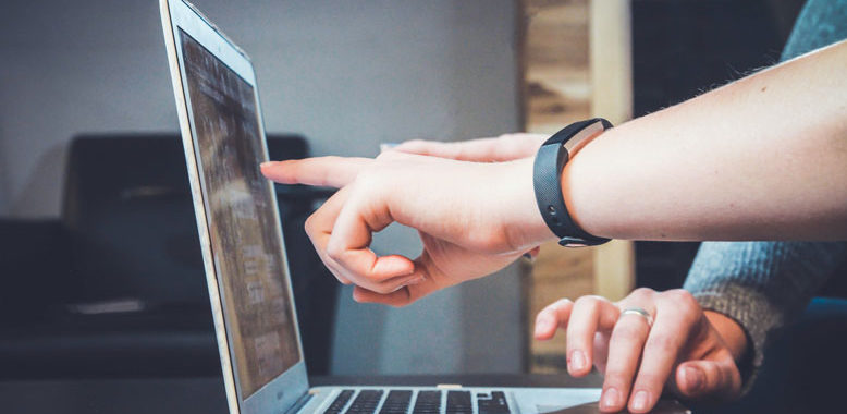 a person pointing at a computer screen