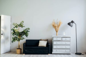 a couch and a dresser and light staged for a room