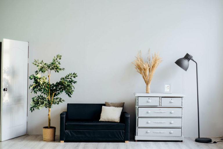 a couch and a dresser and light staged for a room