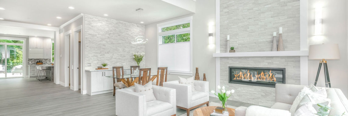 a living room area that looks staged with a nice couch and fire place