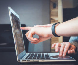 a person pointing at a computer screen