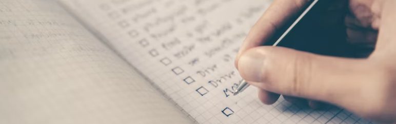 a person writing on a checklist