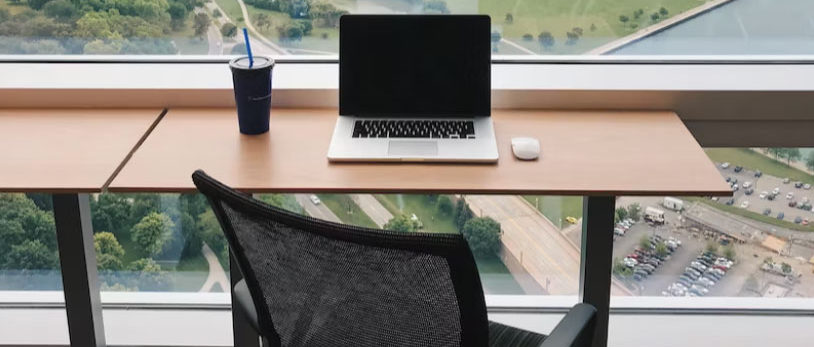 a computer on a desk near a window