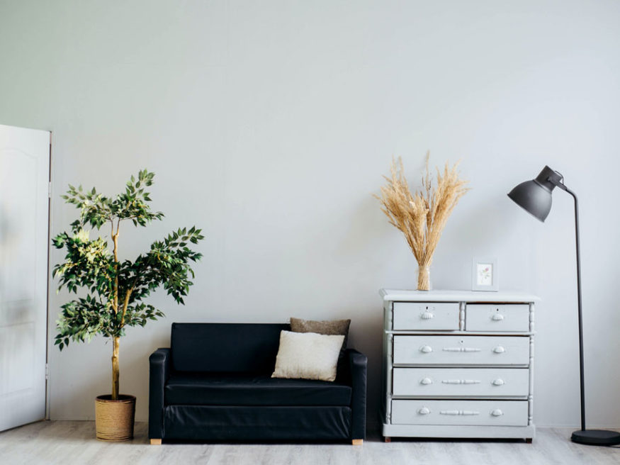 a couch and a dresser and light staged for a room